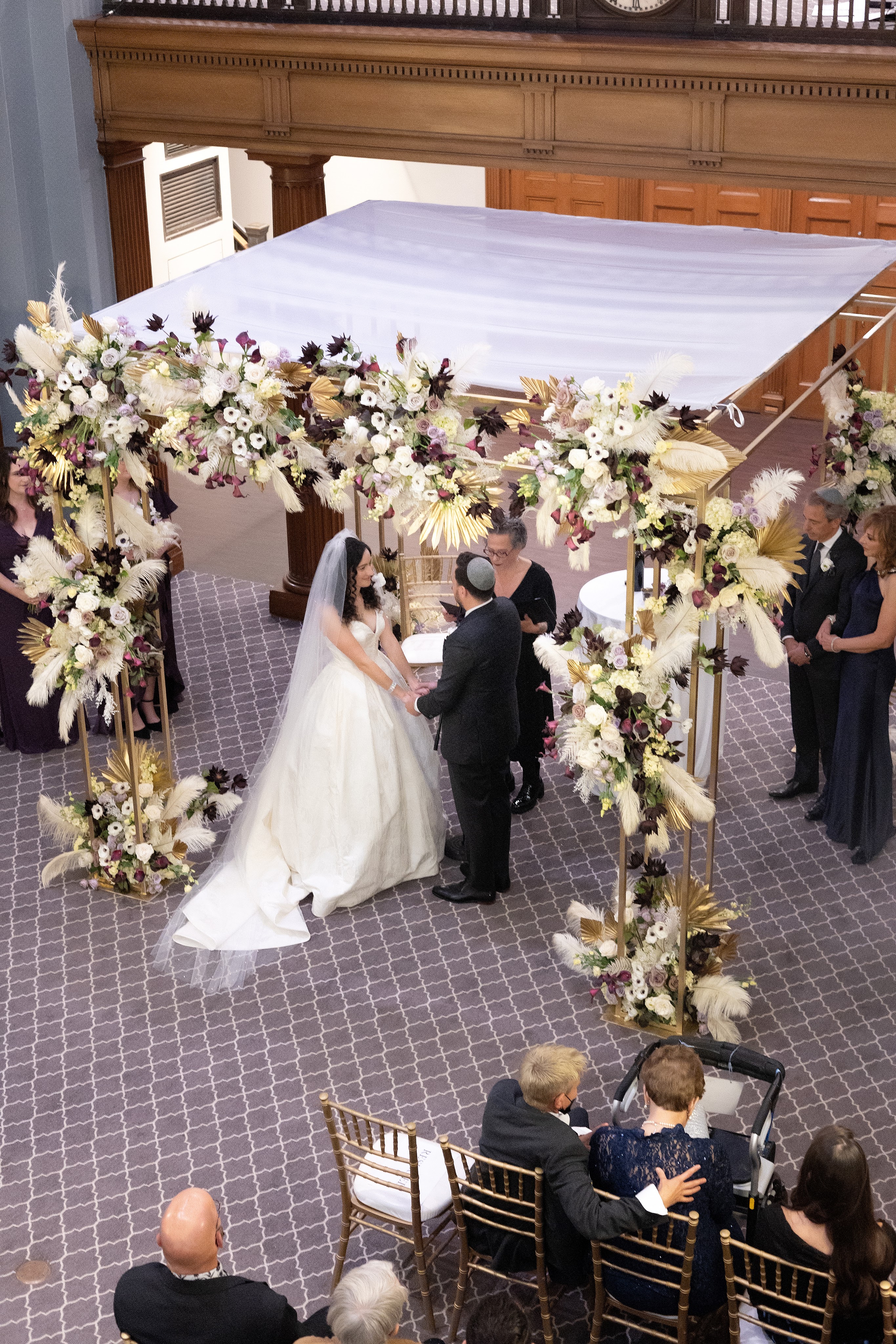 Bride and Groom with wedding officiant SandraLaya Ruch standing under an elaborate chupa (wedding canopy